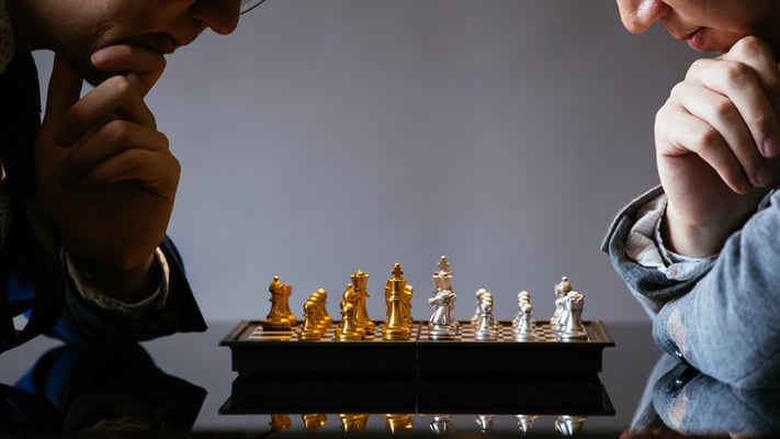 Två män strategiskt planerar sitt nästa drag i ett schackspel